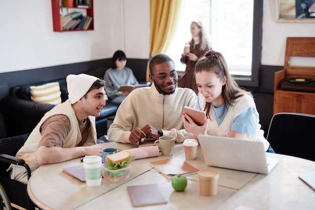 A diverse group of students is gathered around a table, working together on laptops and paperwork. They are engaged in a discussion about financial aid and college applications. The setting is a library or student center.