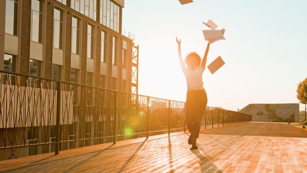 Students celebrating graduation on a sunny day, tossing their caps in the air. The image conveys a sense of achievement and the culmination of their college experience.