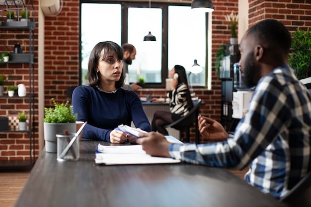 A student participating in a mock interview with a career counselor, demonstrating preparation and guidance. The setting is a college career center, with brochures and resources visible in the background.