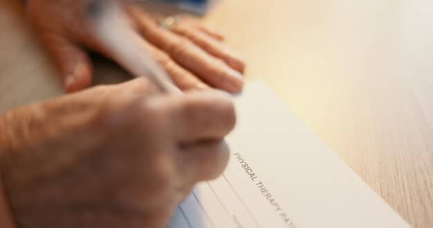 A close-up of a hand pointing to a specific clause in a loan forgiveness application form, highlighting the detail and importance of understanding the terms and conditions.