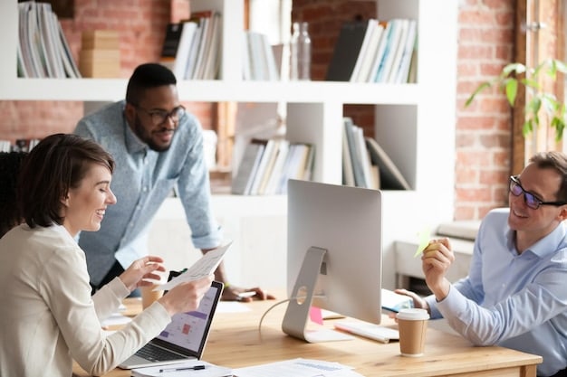 A brightly lit office space, with diverse professionals collaborating around a table. Laptops and documents are spread out, indicating active engagement and discussion. The atmosphere is positive and teamwork-oriented.