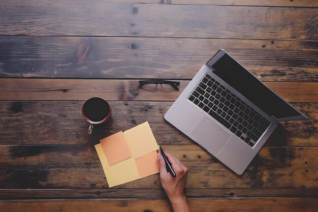 A hand writing a letter at a desk, with a laptop displaying a FAFSA form in the background. The scene should convey focus and determination.